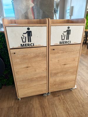 deux poubelles en bois posées par terre, sur lesquelles sont apposées des étiquettes