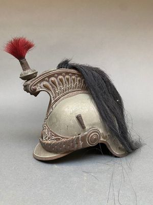 un vieux casque orné d'une plume rouge sur le dessus