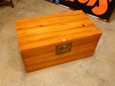 a small wooden box sitting on the floor next to a sign