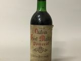 une vieille bouteille de vin posée sur une table blanche