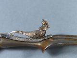 a bird on top of a knife on a table