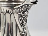 a close up of a silver coffee pot on a white surface