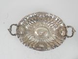 an antique silver plate with handles and handles on a white surface