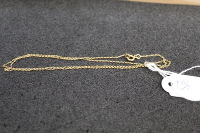 un collier en or muni d'une breloque, posé sur une table