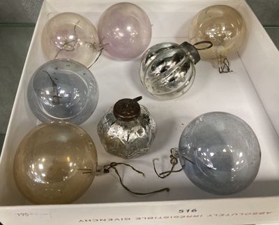 six boules de Noël en verre dans une boîte posée sur une table