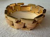 bracelet made of gold plated metal on a white surface