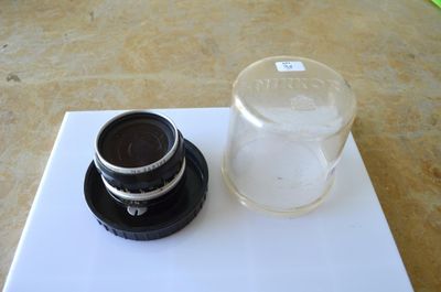 a glass of water and a camera lens on a table