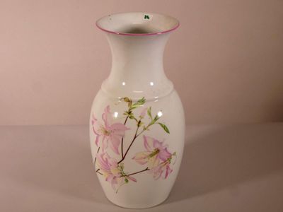 un vase blanc orné de fleurs roses peintes dessus