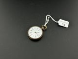 a close up of a pocket watch on a table with a price tag
