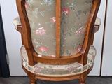 a wooden chair with a floral upholstered back