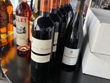 many bottles of wine sitting on a table next to a toaster and toaster