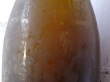 a bottle of beer sitting on a table next to a wall