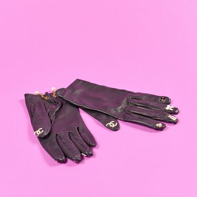 deux gants en cuir noir ornés de perles, sur fond rose