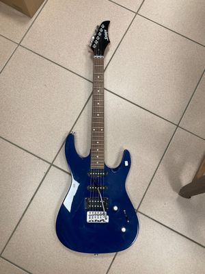 une guitare électrique bleue posée par terre dans une pièce