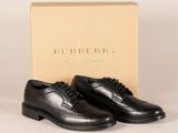 une paire de chaussures noires devant une boîte