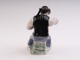 a figurine of a man sitting on a bench