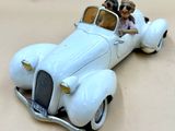une petite voiture avec deux personnages à l'intérieur, posée sur une table