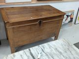 a wooden chest sitting in a room with pictures on the wall
