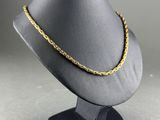 a black mannequin with a gold chain on it
