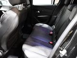 the back seats of a car are black with a purple seat belt