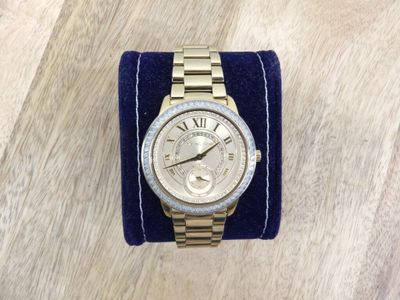 wrist watch on a blue velvet cuff with roman numerals