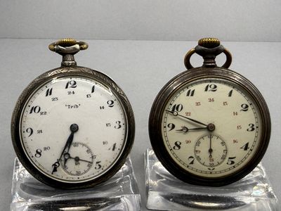pair of antique pocket watches sitting on clear acrylic bases