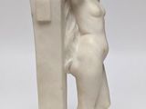 an image of a statue of a woman leaning against a wall