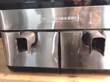 a woman taking a picture of a stainless steel appliance