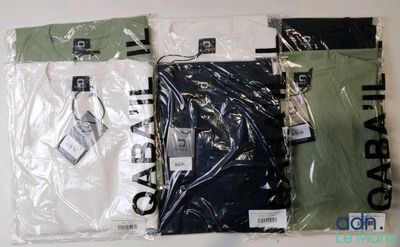 plusieurs chemises sont emballées dans des sacs en plastique, posées sur une surface blanche