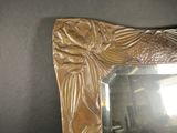 a mirror with a bird on it on a table