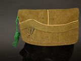 a green hat with a pair of scissors on it