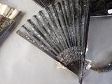 a black fan sitting on a table next to a book