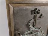 a metal plaque with a fish on it on a wall