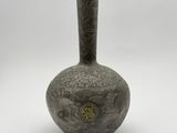 un vase avec un motif sur une surface blanche