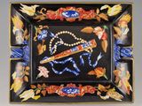 une assiette noire sur laquelle est représenté un cheval et des fleurs
