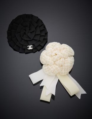 deux accessoires pour cheveux noirs et blancs posés sur une surface noire