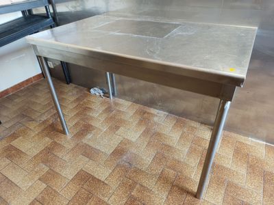 a stainless steel table in the middle of a kitchen