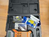 une boîte à outils contenant une calculatrice et d'autres objets, posée sur une table
