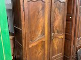 une armoire en bois dans une pièce dont la porte est verte