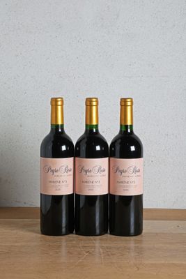 three bottles of wine sitting on top of a wooden table