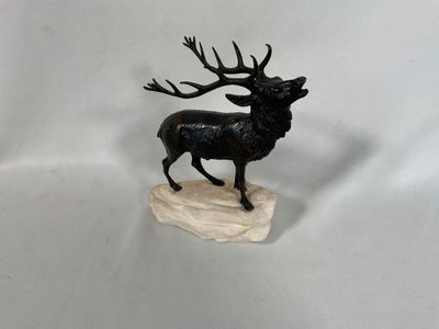 figurine représentant un cerf aux bois imposants, debout sur un rocher