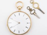 a gold pocket watch and a pair of scissors on a white surface