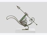 a bronze sculpture of a bird with a long tail on a base
