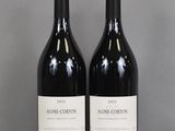 two bottles of wine sitting on top of a table next to each other
