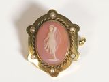 an image of a pink and gold broochle with a lady in a veil