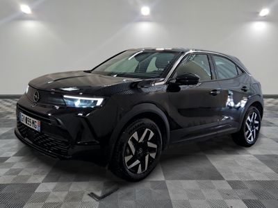 un 4x4 noir garé dans un garage au sol en damier