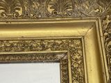 an ornate gold frame with a mirror in the middle