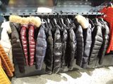 many jackets hanging on a rack in a store