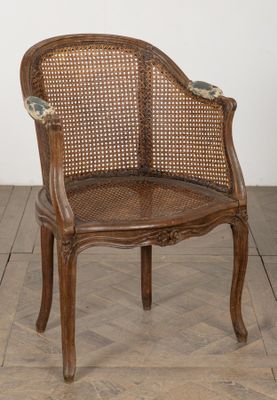a wooden chair with a woven seat on a wooden floor