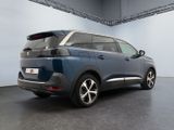 the rear end of a blue car parked in a garage
